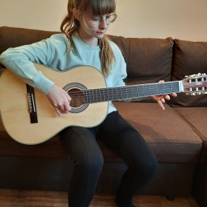 M. Malńska podczas gry na gitarze.