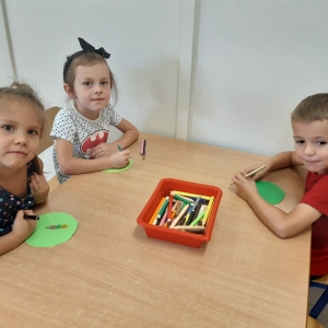 Dzieci siedzą przy stoliku i malują obrazek