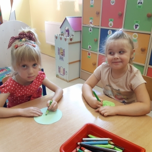 Dzieci siedzą przy stoliku i malują obrazek