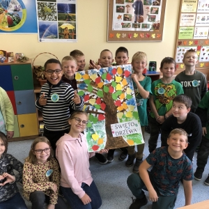 Uczniowie w klasie prezentują plakat przedstawiający drzewo.
