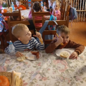 Dzieci zajadają kiełbaskę z grilla