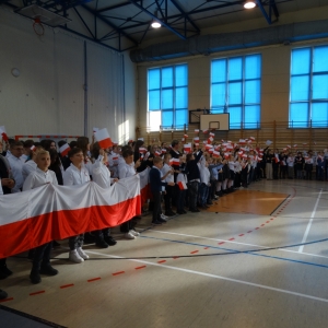 Uczniowie z flagami podczas śpiewania pieśni patriotycznych