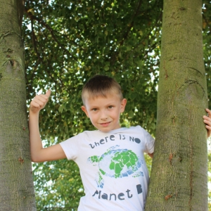chłopiec stojący przy drzewie