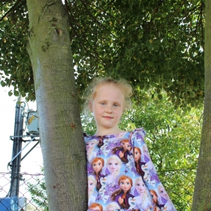 dziewczynka stojąca przy drzewie